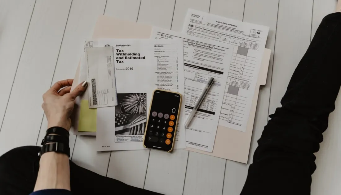 Paperwork and a calculator for comparing health program costs.